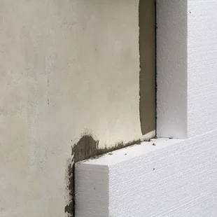 Schutz gegen Rissbildung - Nahaufnahme Detail der verputzten Hauswand mit starren Styropor-Isolierung. Moderne Technik, Bau, Renovierung, Energiesparen, Alternative für Mineralwolle, warme komfortables Haus Konzept. - Stock-Fotografie