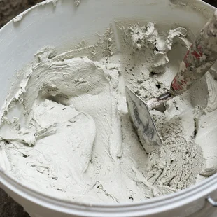 Multi-Mörtel - Mixed white Cement prepared in a plastic bucket in construction - Stock-Fotografie