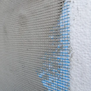 Armierungsgewebe im Armierungsmörtel - Isolierung des Hauses mit Styropor. Energiesparkonzept. Closeup - Stock-Fotografie